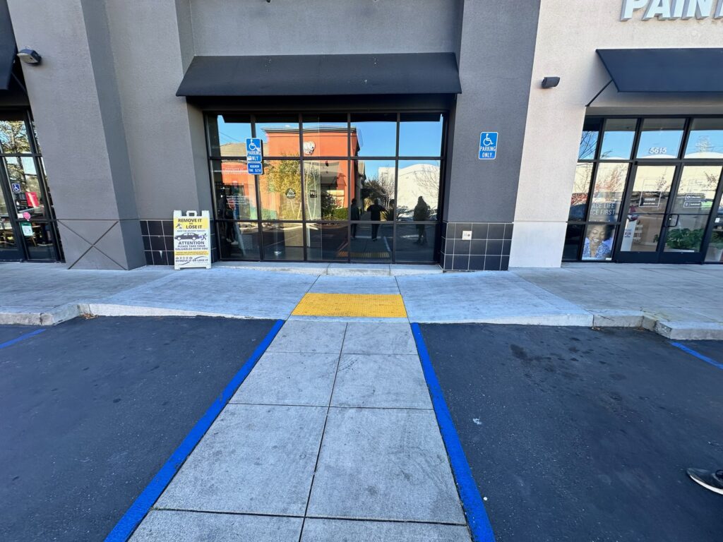 ADA-compliant accessible path and curb ramp at a commercial storefront, South Bay Area